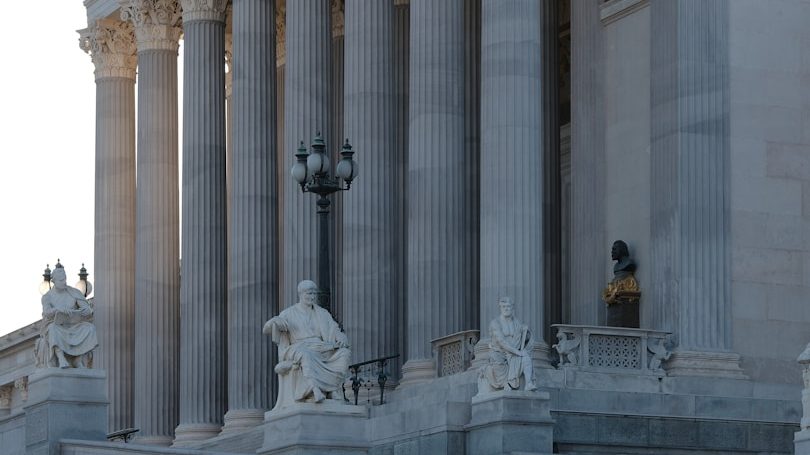 A large building with columns and a flag on top of it